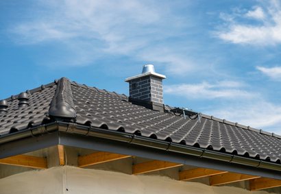 Inspector checking roof chimney flashing in Highlands Ranch