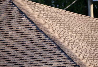 Roofer nailing asphalt shingles on a Highlands Ranch home